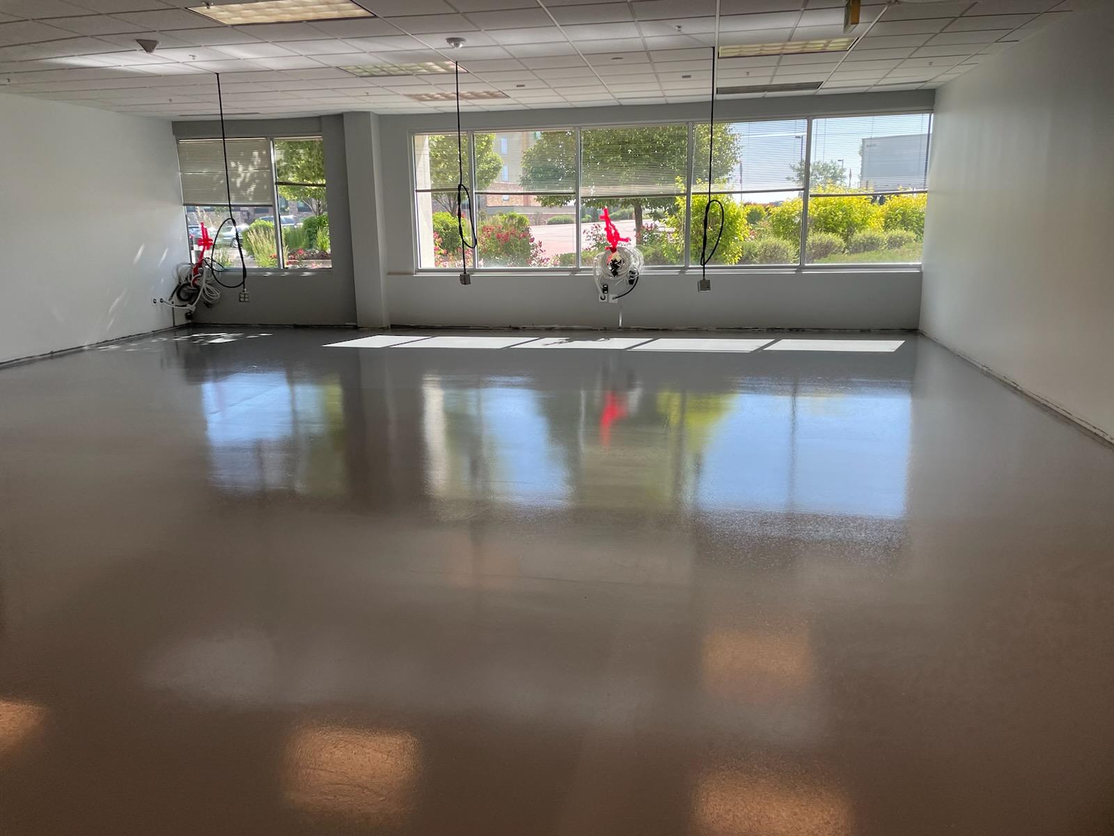 Smooth reflective epoxy flooring in commercial space with large windows — epoxy flooring Denver