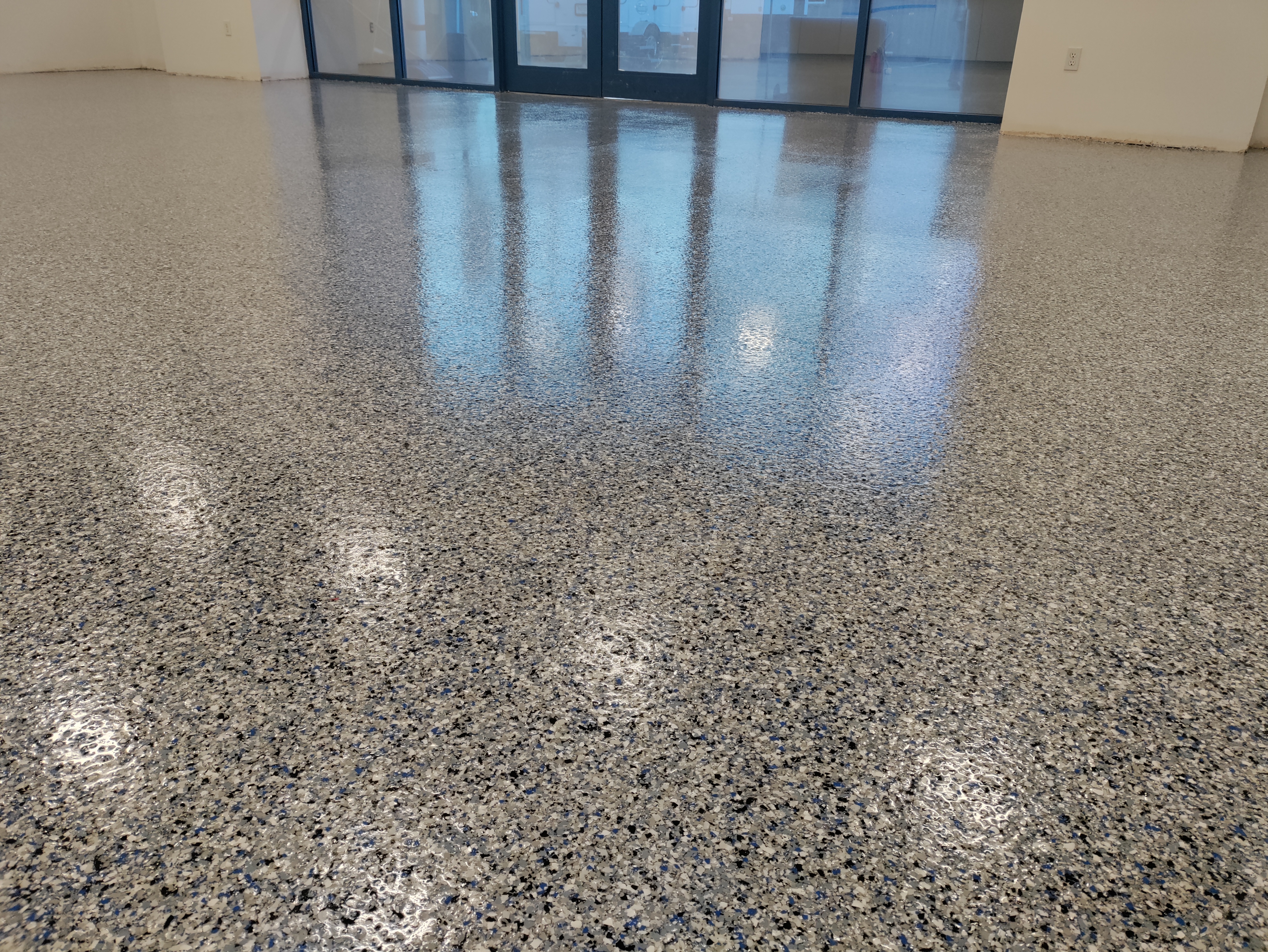Flake epoxy floor with high gloss reflecting glass storefront doors — commercial flake epoxy