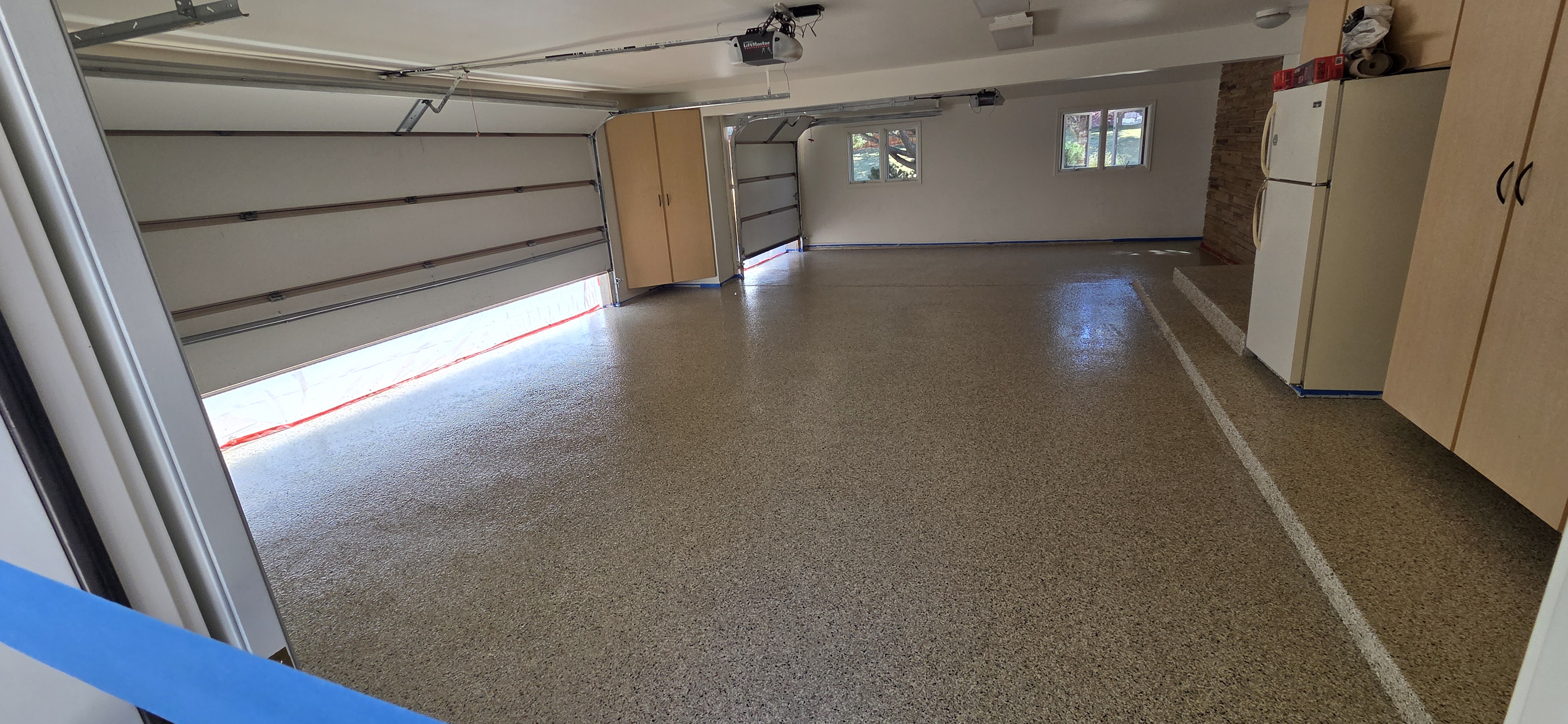 Wide-angle flake epoxy garage floor with cabinets and storage — garage floor coating Denver CO