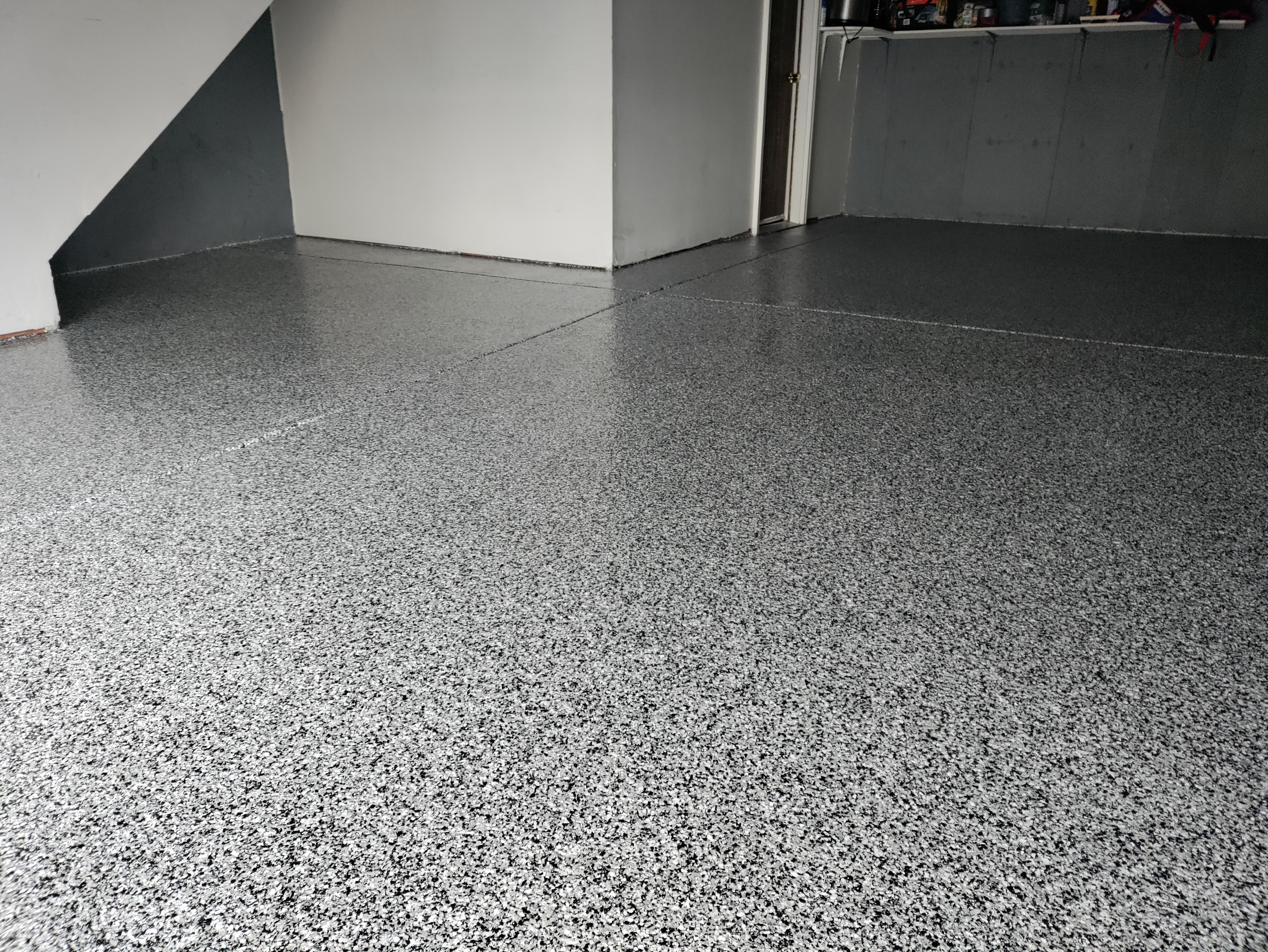 Gray flake epoxy coating in residential basement with staircase — basement epoxy flooring Colorado
