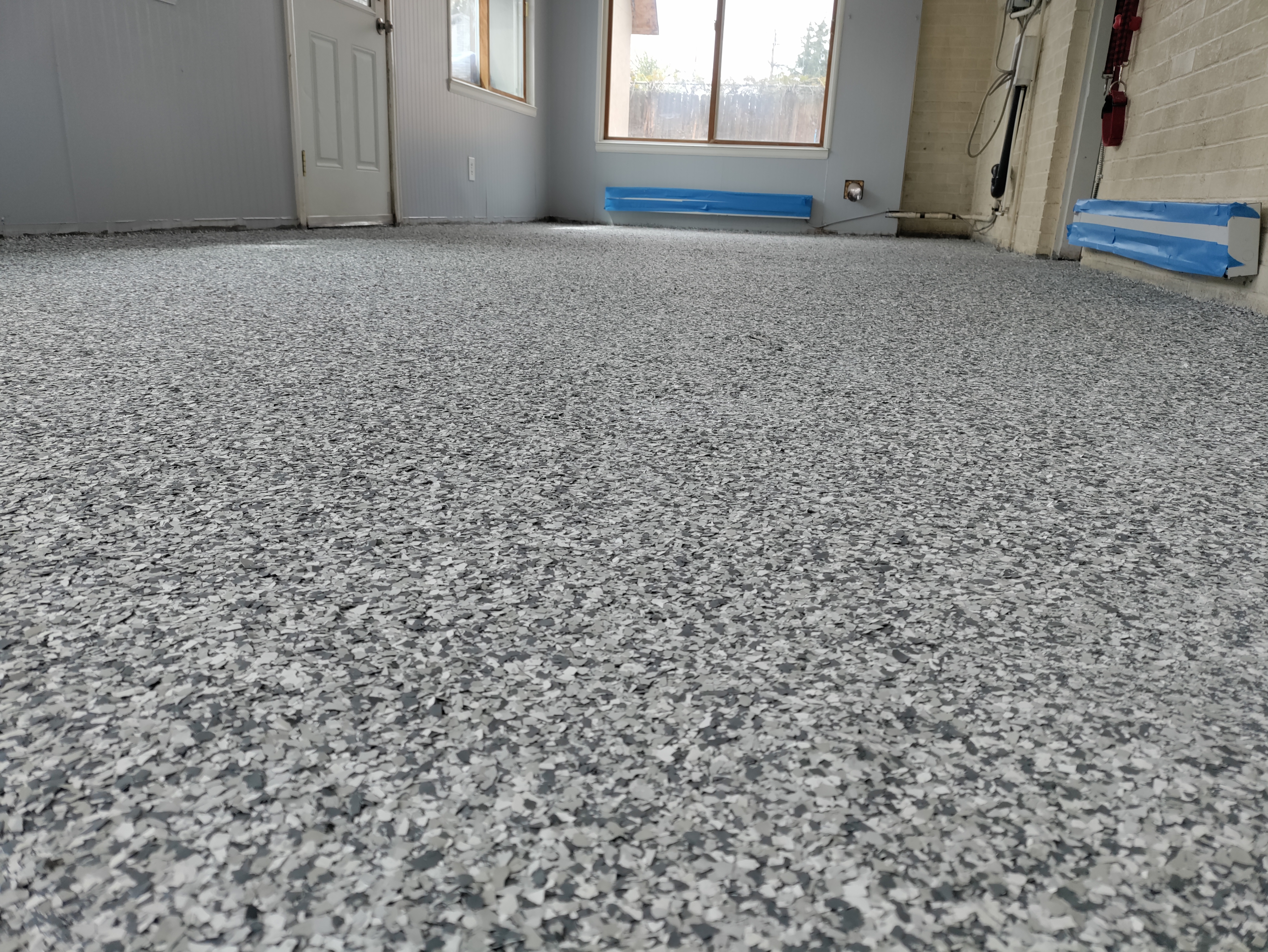 Flake epoxy with urethane topcoat in residential room with blue tape masking