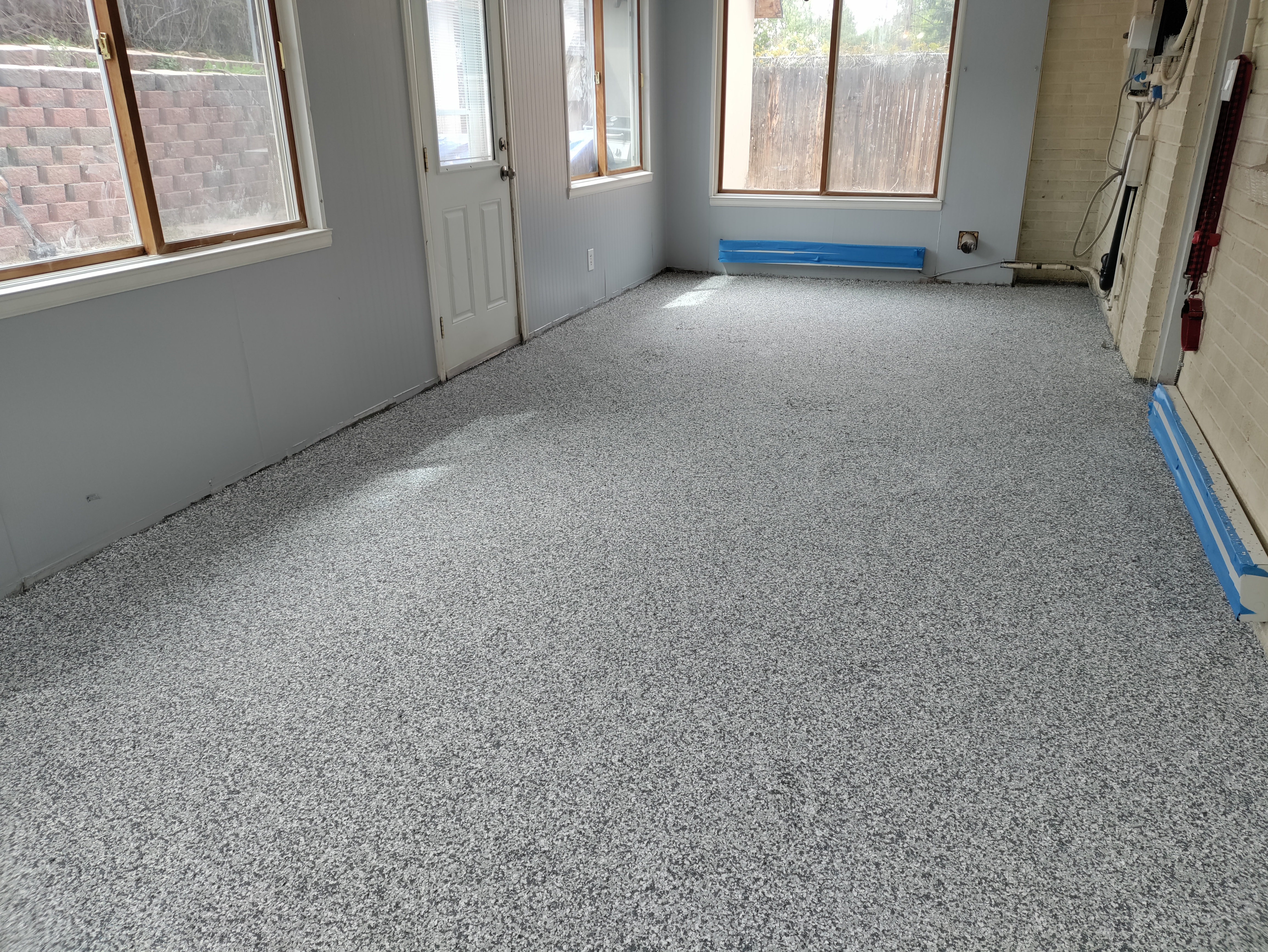 Flake epoxy floor in residential sunroom with natural window light — residential flake epoxy Colorado