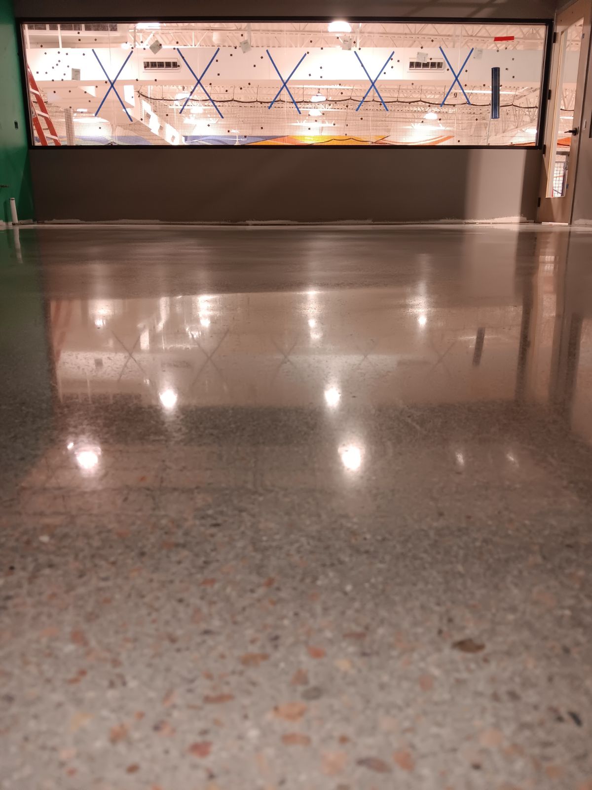 Exposed aggregate polished concrete with high reflectivity in commercial warehouse