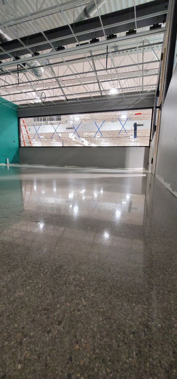 Wide-angle polished concrete with exposed aggregate in industrial warehouse space