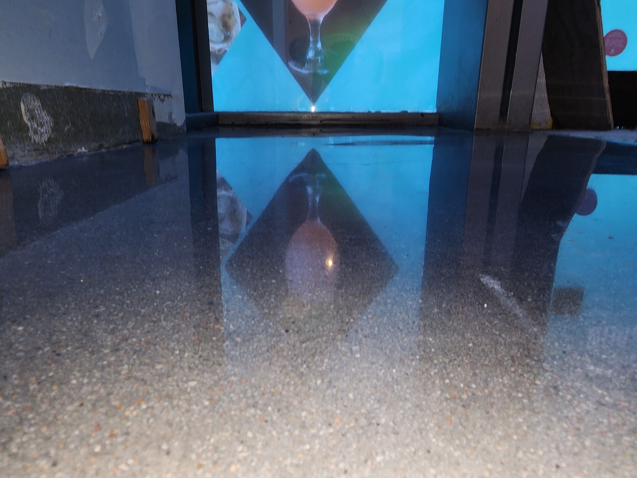 Polished concrete floor reflecting bar signage in restaurant — commercial concrete polishing
