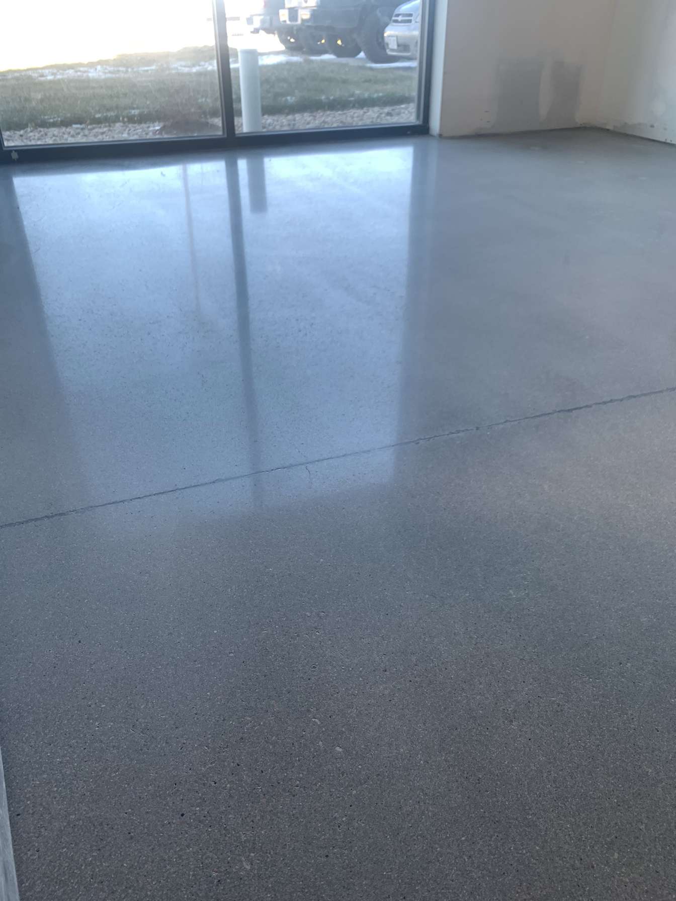 Polished concrete garage floor reflecting window light — concrete polishing Colorado