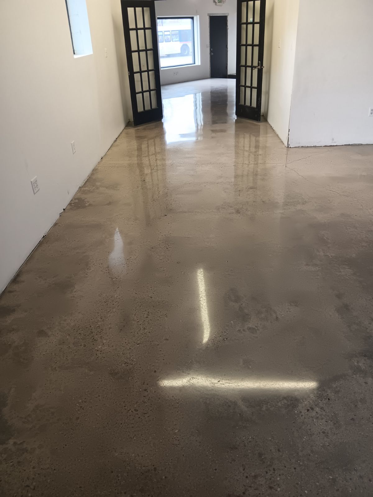 Polished concrete hallway with french doors reflecting natural light