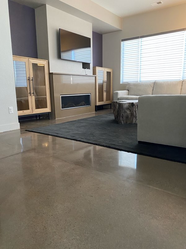 Polished concrete in modern living room with fireplace and entertainment center — residential polished concrete Colorado