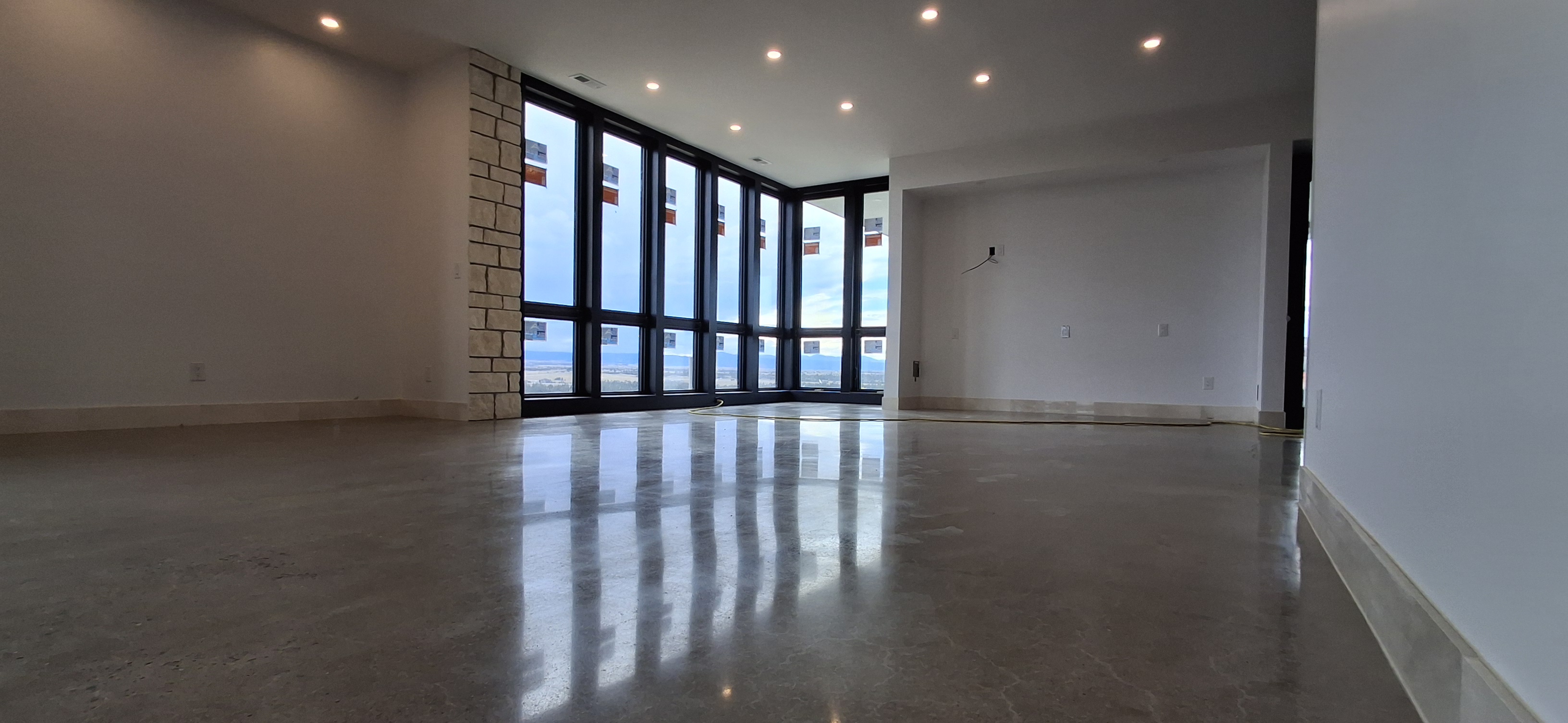 Polished concrete living room with recessed lighting and mountain views — Colorado home