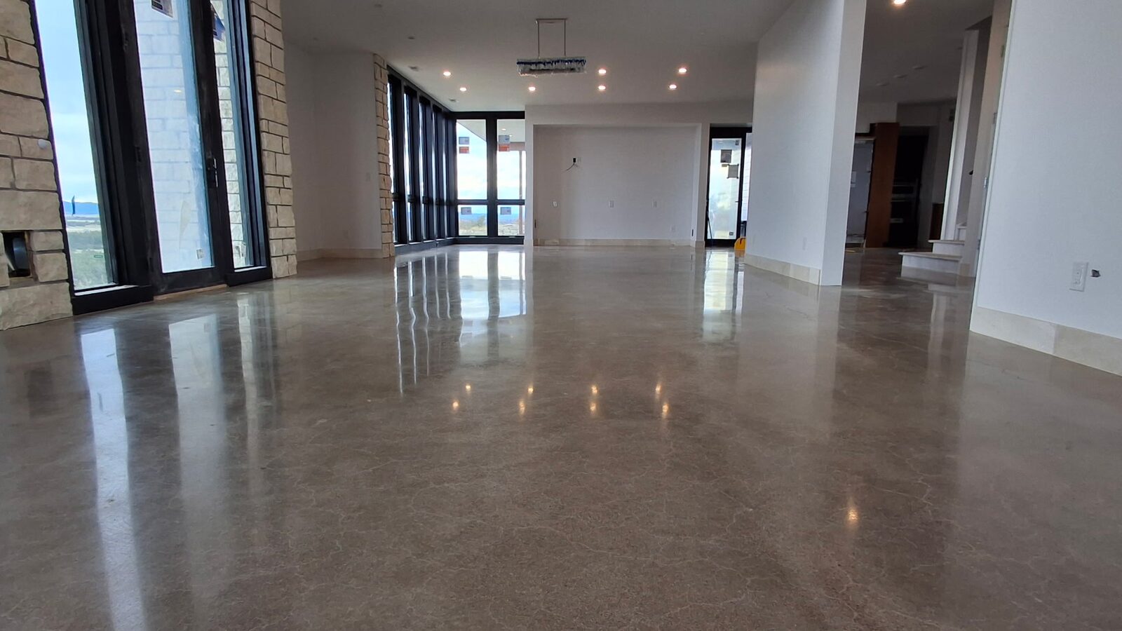 Polished concrete reflecting natural light through glass doors — residential concrete polishing