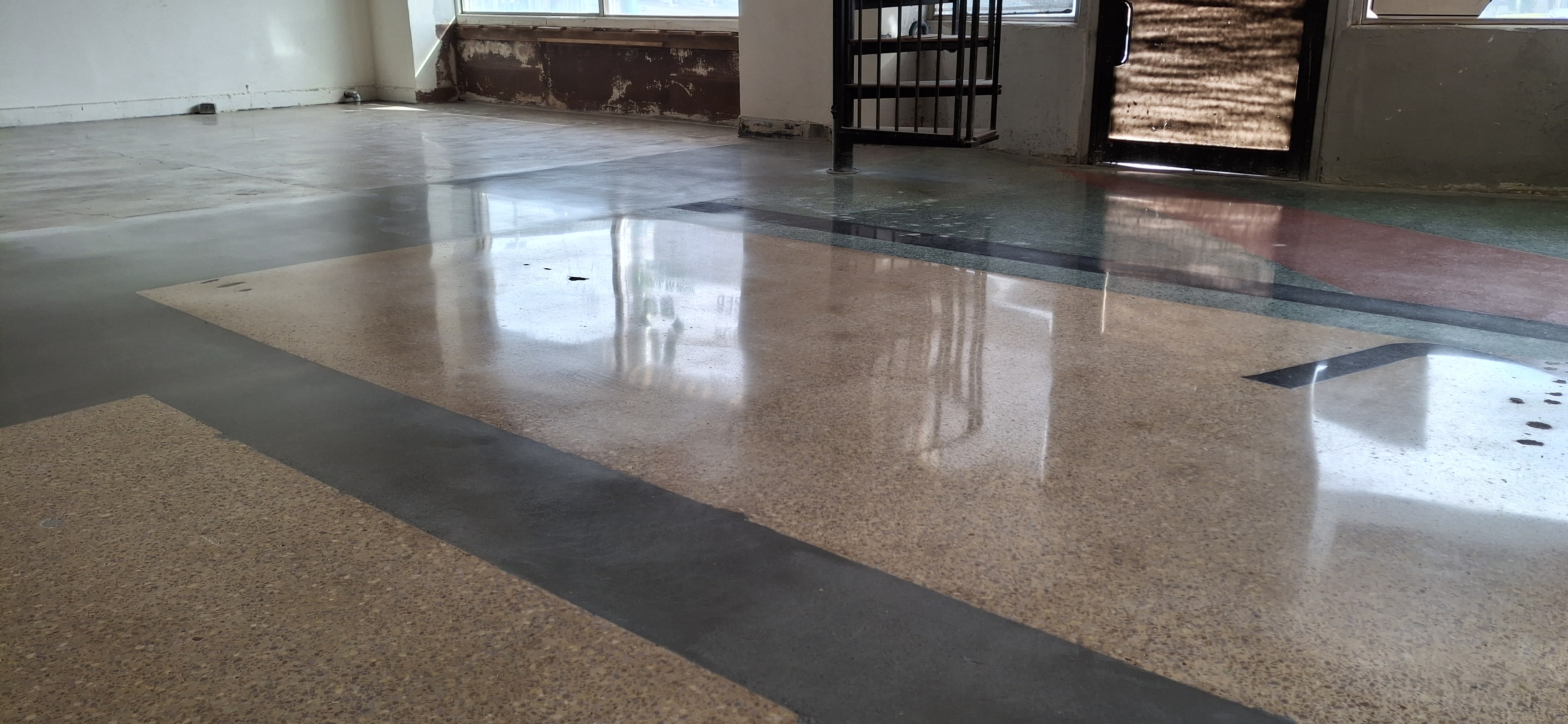 Polished terrazzo concrete with geometric border pattern in commercial space