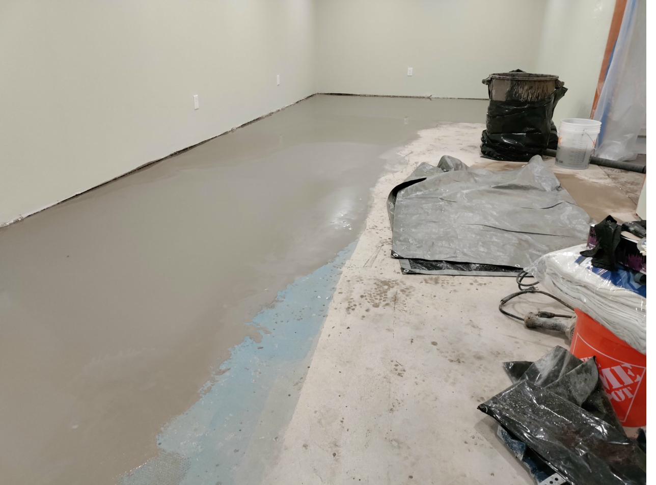 Epoxy basecoat being applied to a prepared concrete floor by Visionary Floors