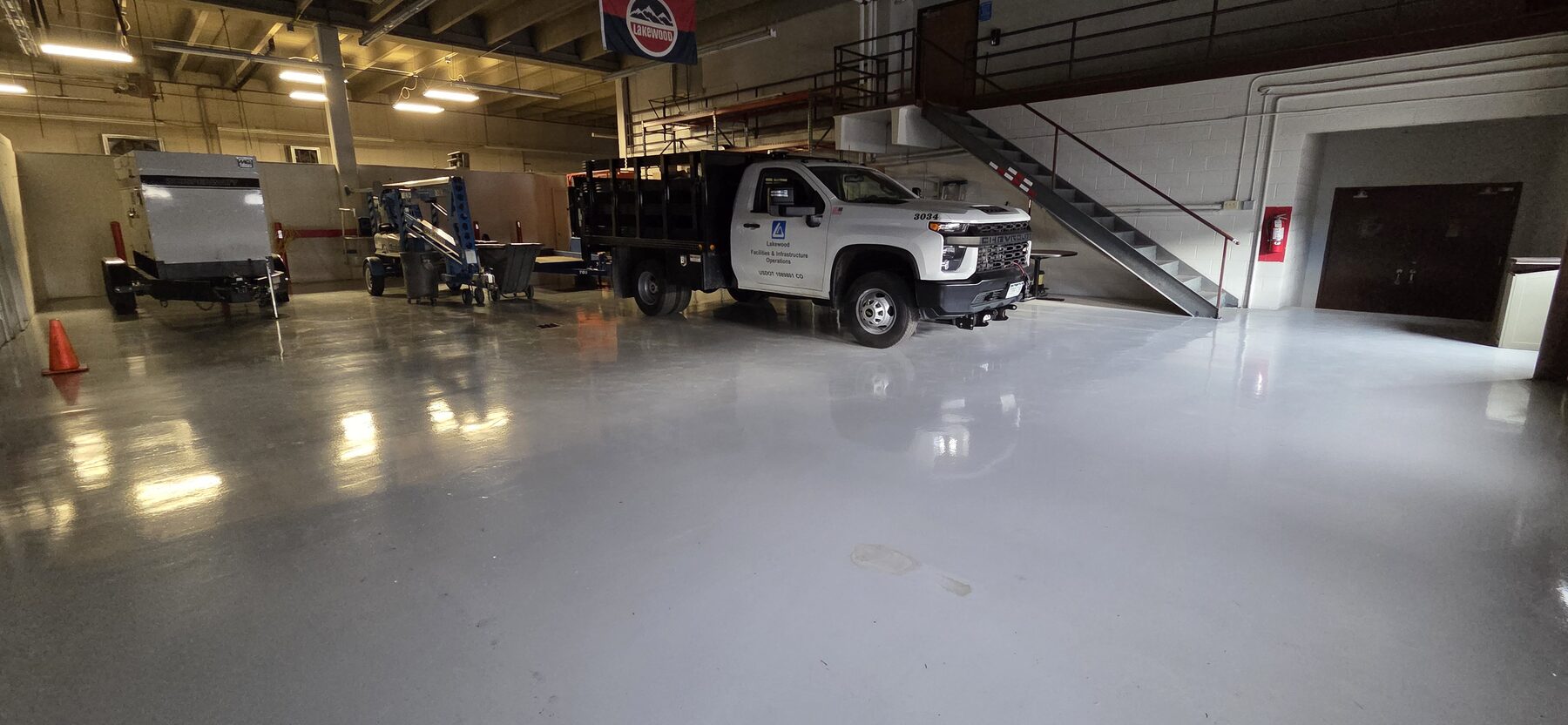 Gray traffic coating in municipal vehicle bay with Lakewood facilities truck and equipment — traffic coatings Colorado